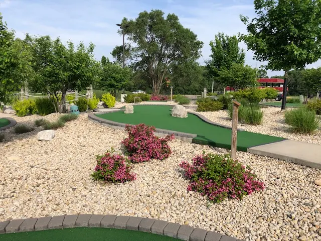 Landscaped mini golf hole with pink flowers