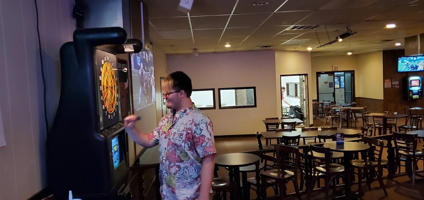 Guest throwing darts in the arcade area